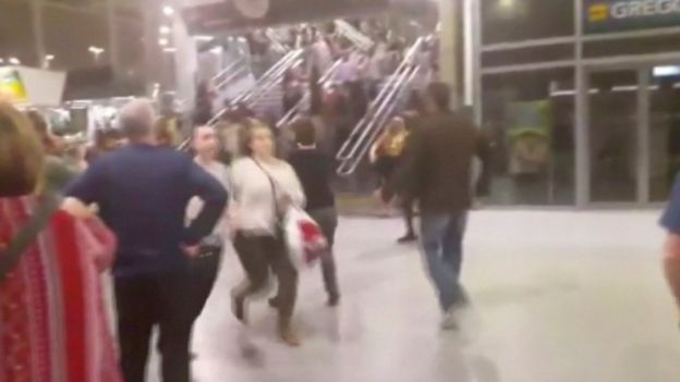 People running down stairs as they attempt to exit the Manchester Arena