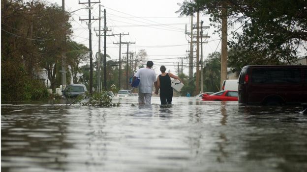 Una pareja camina por una calle inundada de Key West Florida
