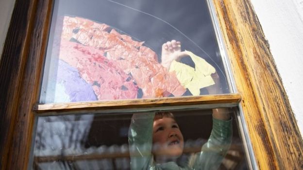 طفل يرسم قوس قزح على النافذة