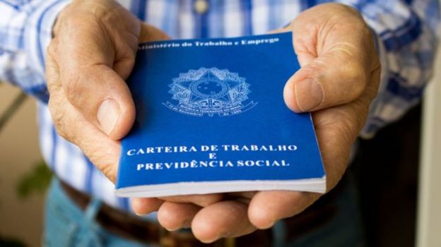 Homem segura carteira de trabalho