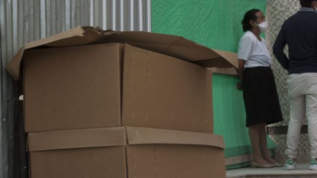 Cardboard coffins with bodies await outside Jardines de Esperanza cemetery in Guayaquil