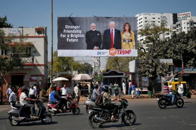 People ride their motorbikes past a hoarding with the images of India"s Prime Minister Narendra Modi, U.S. President Donald Trump and first lady Melania Trump ahead of Trump"s visit, in Ahmedabad, India, February 18, 2020.
