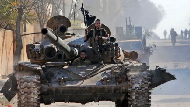 Turkey-backed Syrian fighters ride on a tank in the town of Saraqeb, Syria's Idlib province. Photo: 27 February 2020