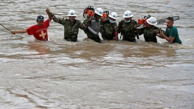 Hombres tratan de cruzar un río crecido en Putumayo