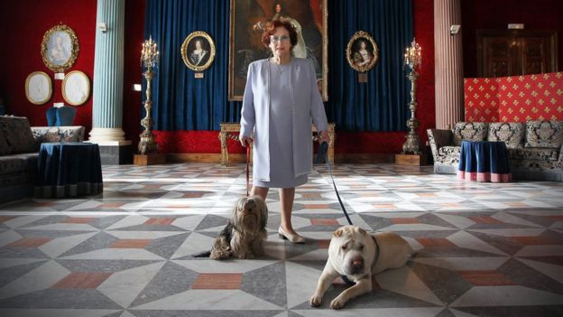 Jeanne Augier, owner of the famous Negresco hotel, poses with her dogs in the Versailles lounge of the palace in Nice, south-eastern France, 13 January 2011