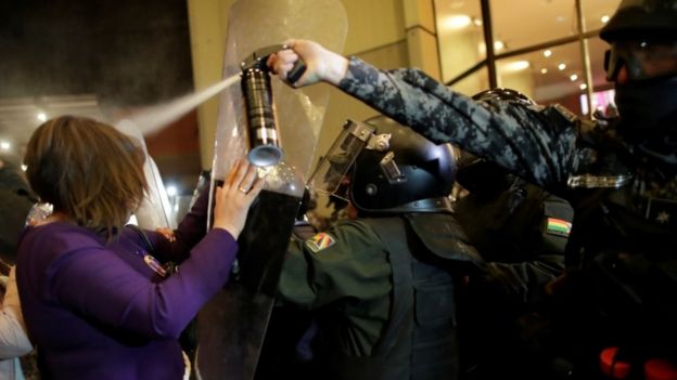 Policía gaseando a una manifestante en Bolivia.