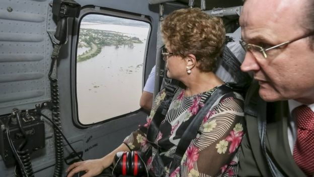 Brazil's President Dilma Rousseff (left) looks out of a plane window during a flight over flooded areas. Photo: 26 December 2015