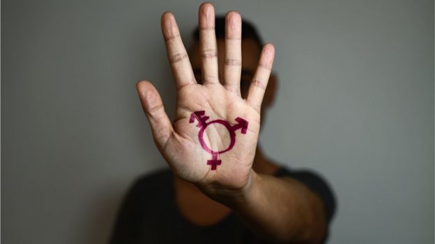 Pessoa com símbolo da transexualidade na palma da mão