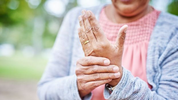 Imagem de senhora apertando uma mão com a outra, indicando local com artrite