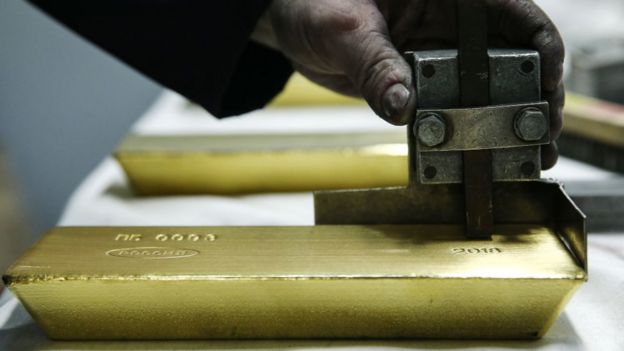 Trabajador puliendo una barra de oro