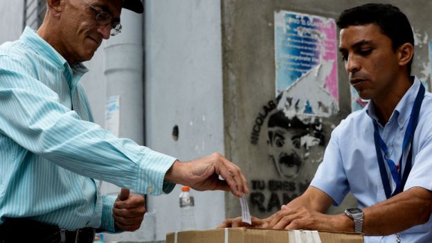 Un señor deposita su voto