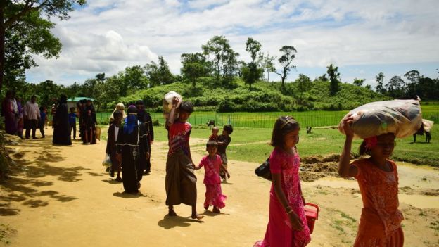 রবিবার বালুখালি শিবিরের পাশ দিয়ে হেঁটে যাচ্ছেন রোহিঙ্গা শরণার্থীরা