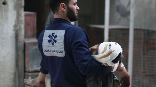 A medic carries an injured person in the rebel-held town of Zamalka, in the Eastern Ghouta (5 February 2018)