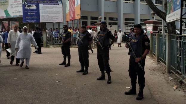 Police stand guard outside the court on 24 March