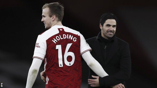 Rob Holding and Mikel Arteta embrace after Arsenal's win against Chelsea