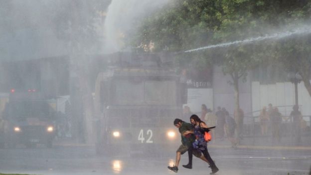 Pareja corre en la protesta