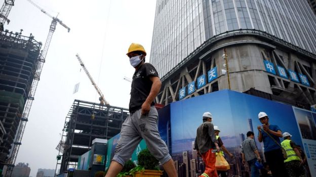 Китайский рабочий на фоне строящегося здания
