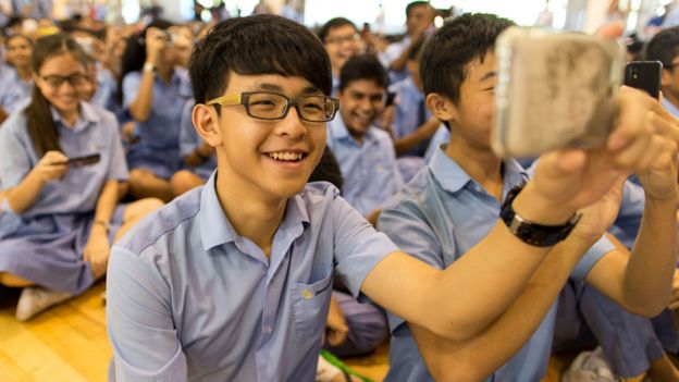 Estudiantes de secundaria en Singapur sonríen en una reunión de grupo