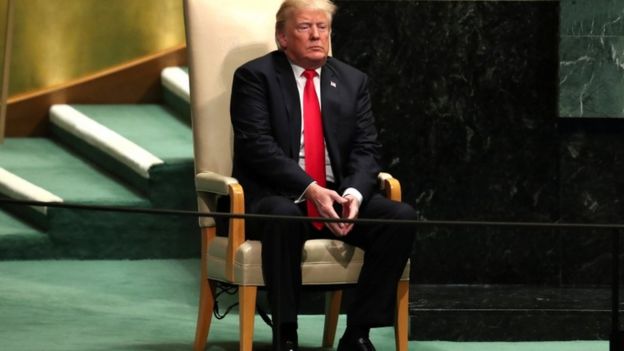Trump sentado numa cadeira nas Nações Unidas em Nova York em setembro de 2018