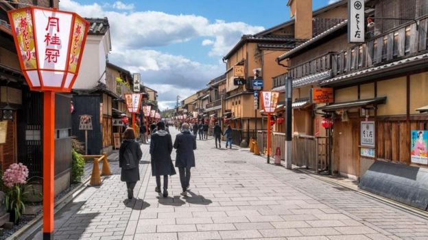 Pessoas caminham pela rua em cidade japonesa