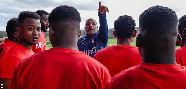 Middlesbrough coach Curtis Fleming shows refugee footballers around the club's training base