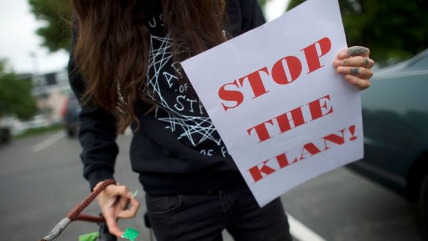 Una persona con un cartel que dice "Paren al Klan"