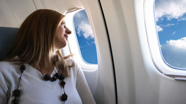 Mujer en la ventanilla de un avión.
