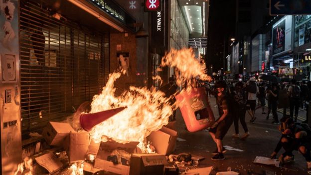 A demonstrator adds to the flames outside a metro station in Hong Kong