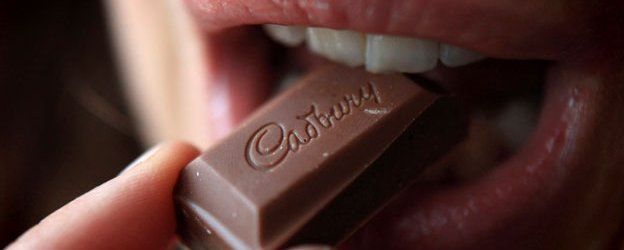 Woman tasting a chunk of Cadbury's chocolate