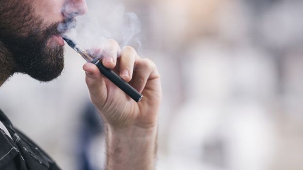 Hombre fumando un cigarrillo electrónico.