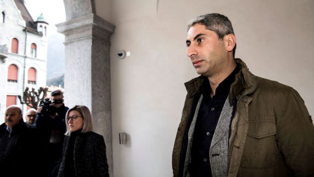 Mr Cosar, clean-shaven and in civilian clothing, arrives at the Federal Criminal Court of Switzerland in Bellinzona