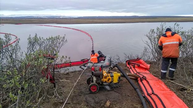 Image shows rescuers as they work near a large diesel spill in the Ambarnaya River