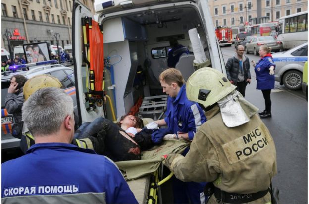 救护人员在塞纳亚·普罗施查德站外将一名伤者送上救护车。