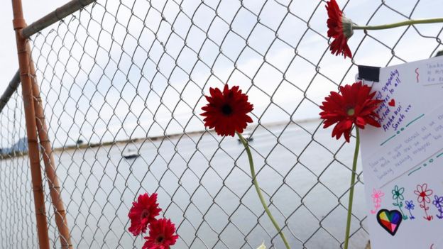 Flowers and cards at a fence