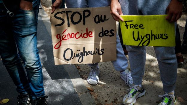 Demonstrators hold posters reading "Stop Uyghurs Genocide and Free Uyghurs" during a gathering against China"s alleged abuse of the Muslim Uyghurr community in Xinjiang province, near the Chinese embassy in Paris, France, 25 July 2020.