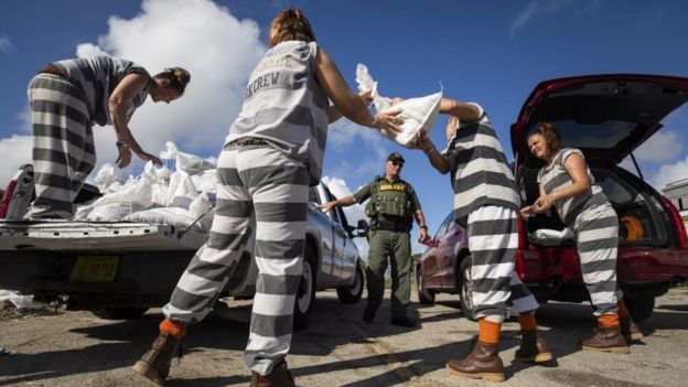 Female inmates from Brevard County Jail load sandbags into a resident's car in Cocoa, Florida