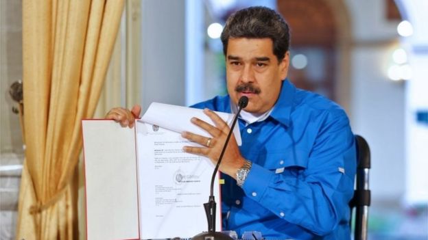 Handout picture released by the Venezuelan Presidency press office of Venezuela's President Nicolas Maduro showing a document as he gives a message in Caracas on February 27, 2019.