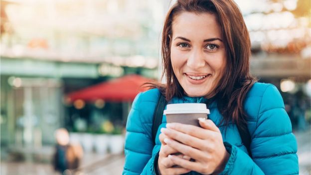 Mujer con un café en las manos en un día de invierno.