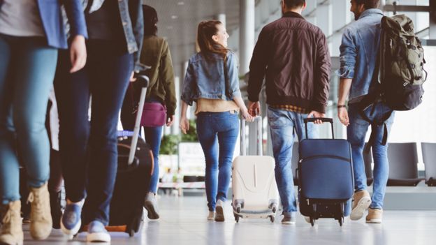 Passageiros com bagagem em um aeroporto