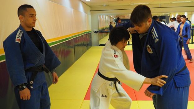 Yuko demonstrates a move while another team members looks on
