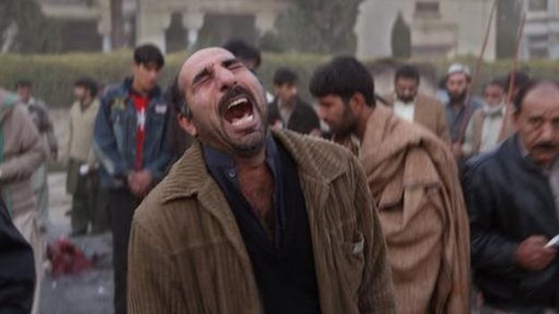Un sobreviviente al ataque contra Bhutto está impactado, cierra los ojos y grita.
