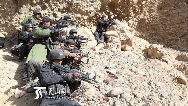 Chinese state media pictures show security forces searching a remote area of rugged terrain in Xinjiang