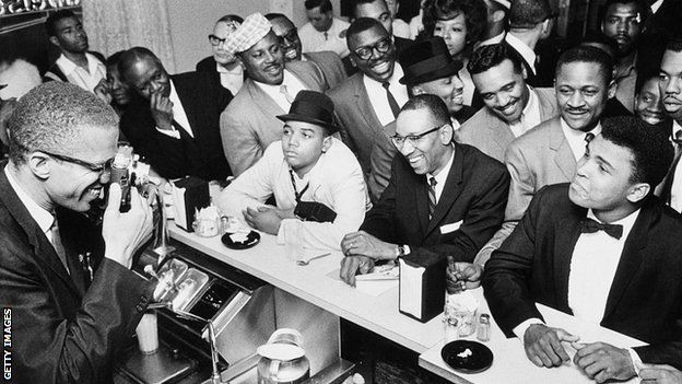 Malcolm X takes a picture of Muhammad Ali in the Hampton House cafe the night the boxer won his first fight with Sonny Liston