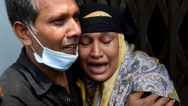 Relatives of a victim of a ferry capsized mourn as rescue workers unload bodies in Dhaka on June 29, 2020