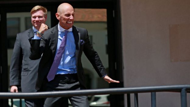 One of Edward Gallagher's lawyers, Marc Mukasey, shown celebrating after the verdict, (his hand is in the air)