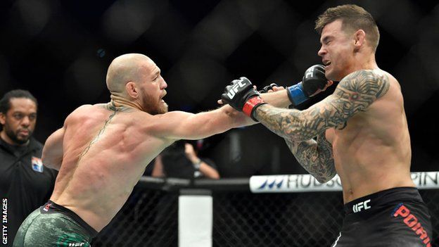 Conor McGregor punches Dustin Poirier during their rematch at UFC 257