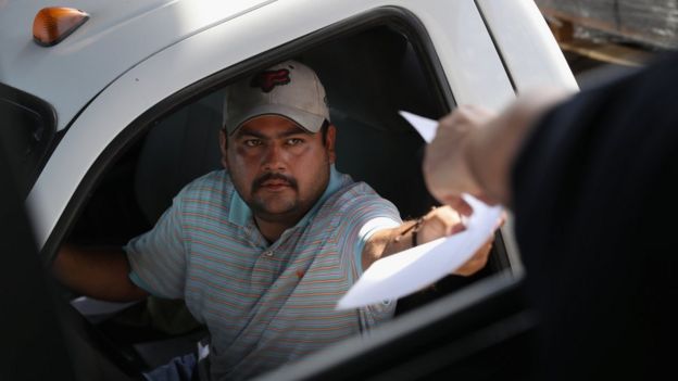 A Mexican trucker hands over manifest documents to a U.S. Customs and Border Protection officer in Laredo, Texas (17 October 2016)