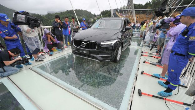 A car filled with passengers drives across the bridge