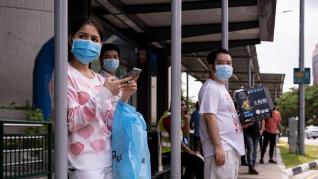 সিঙ্গাপুরের বাস স্টপে অপেক্ষায় থাকা যাত্রীরা।