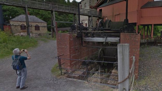A man takes a picture of old mine workings